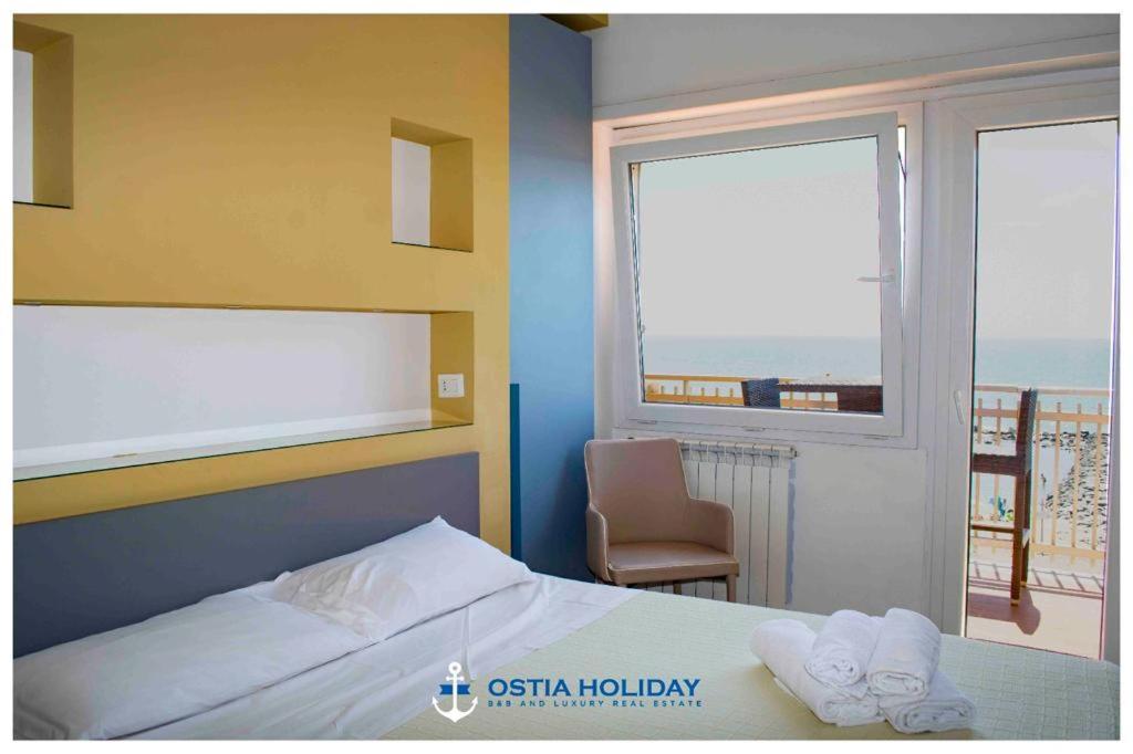 a bedroom with a bed and a window with a view at Sunset in Lido di Ostia
