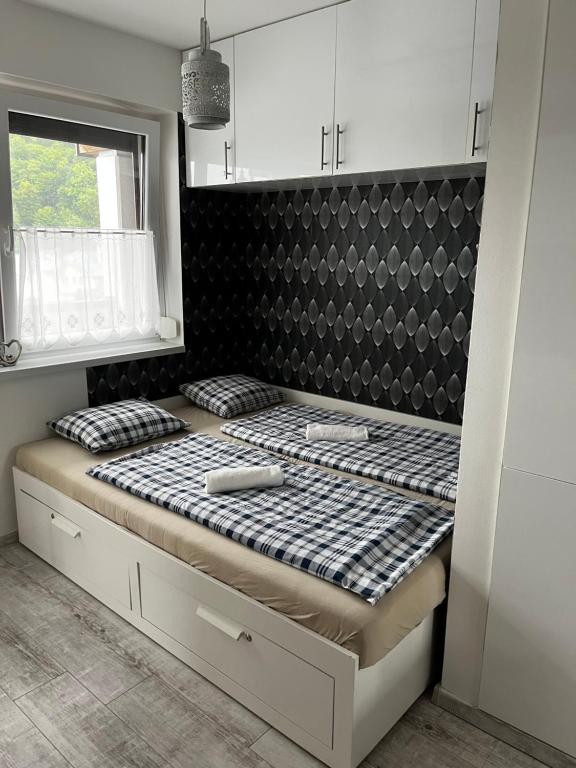 a bed in a room with a black and white at Agnes Apartman in Latschach