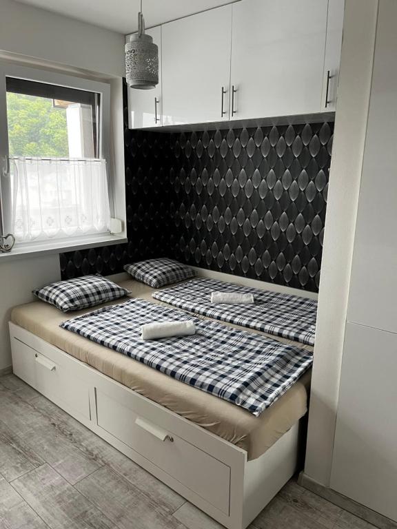 un letto in una camera di colore bianco e nero di Agnes Apartman a Latschach
