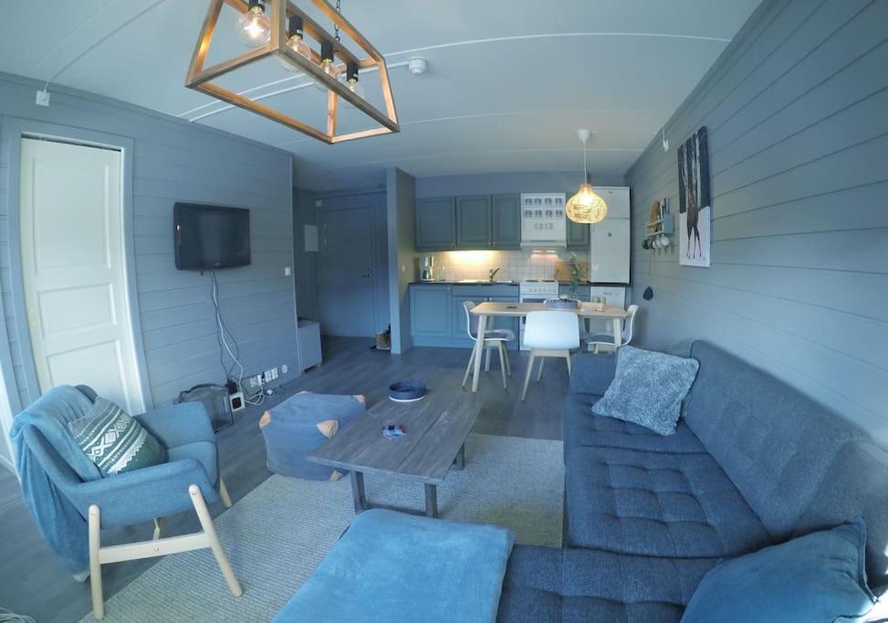 Fjellstova Storehorn Apartments في Torset: غرفة معيشة مع أريكة زرقاء وطاولة