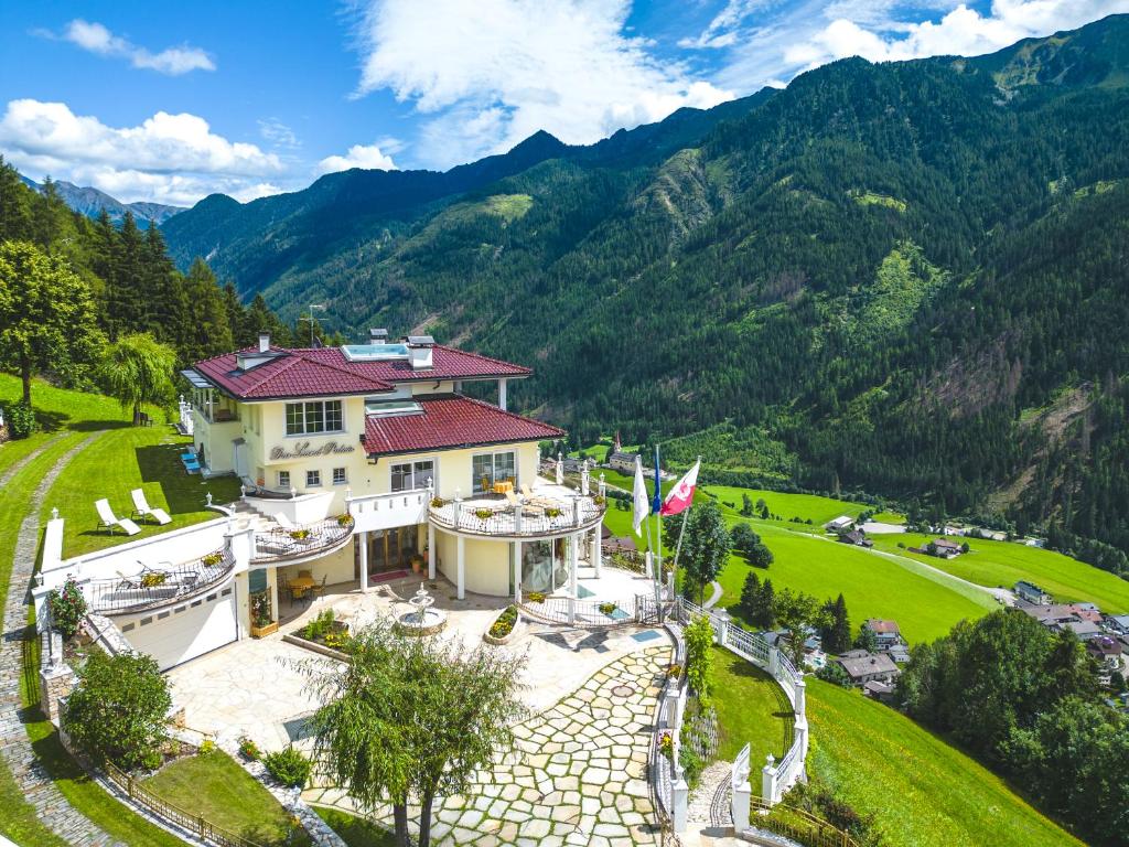 une vue aérienne sur une maison avec des montagnes en arrière-plan dans l'établissement B&B Das Land-Palais - PRIVATE Mountain Hideaway, à Selva dei Molini