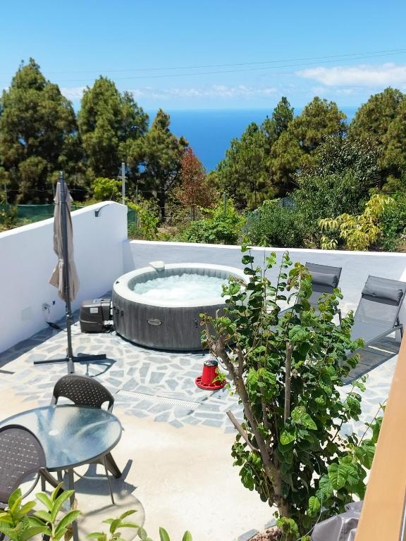 a patio with a hot tub and a table and chairs at casa lipa in La Guancha