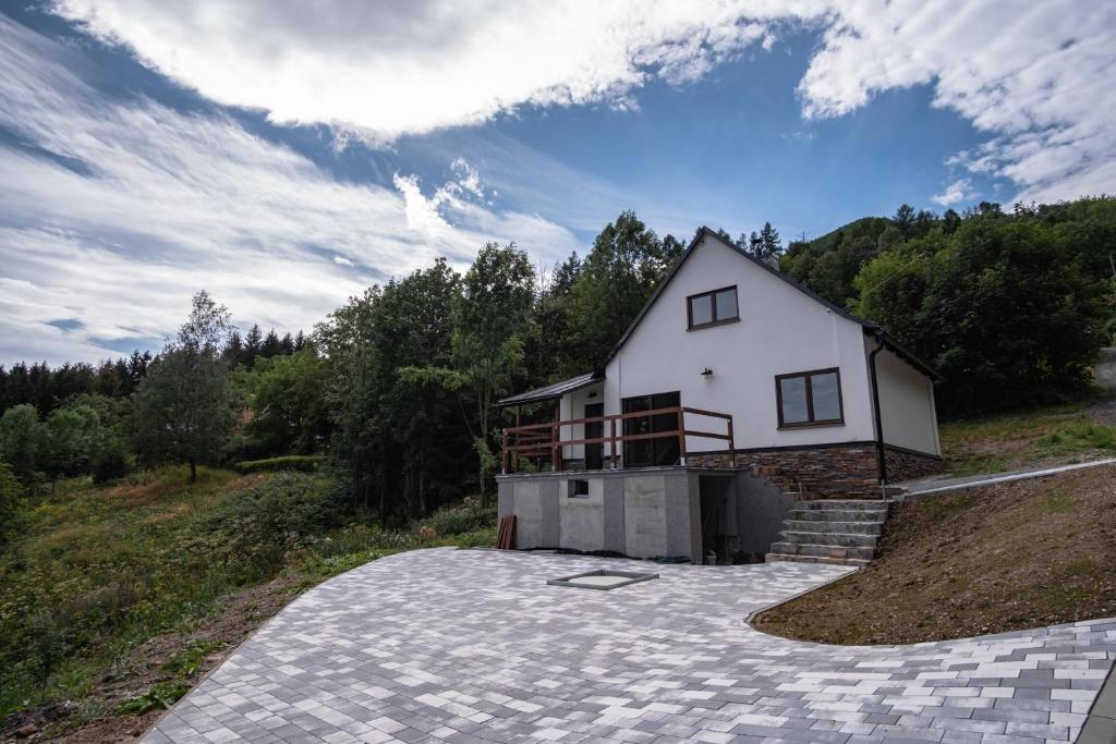 duży biały dom na szczycie wzgórza w obiekcie Horská Chata Čeladná w mieście Czeladna