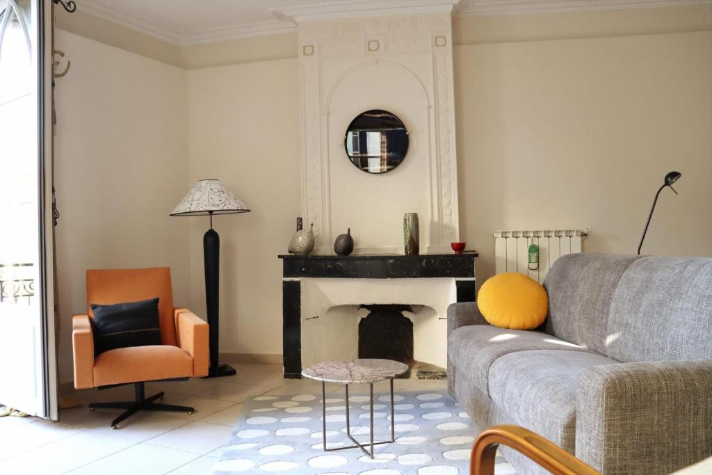 a living room with a couch and a fireplace at Uzès Centre Quartiers des Arts Charme de l'ancien in Uzès
