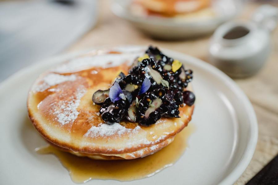 a white plate with a pancake with fruit on it at The Bonnie Badger in Gullane
