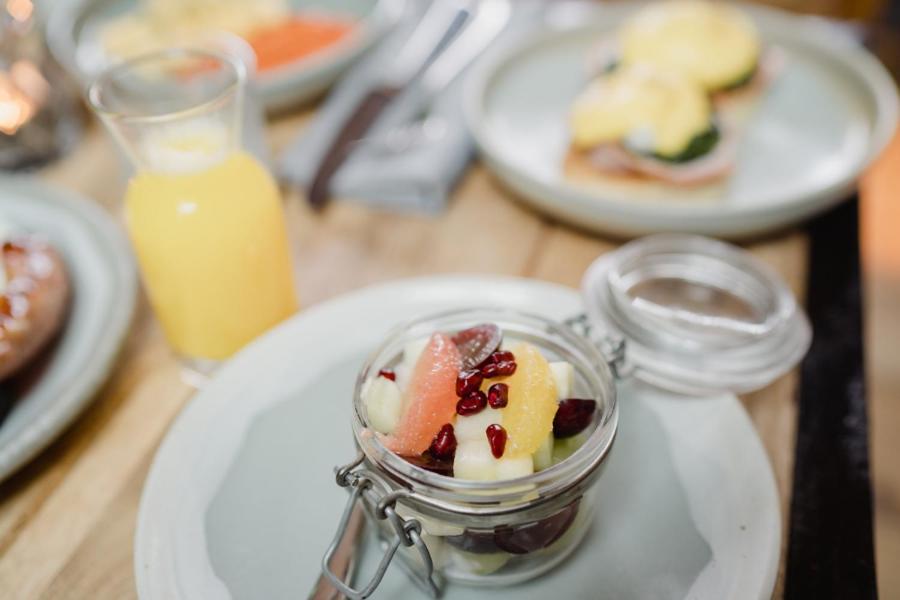 a table with plates of food and a glass jar of fruit at The Bonnie Badger in Gullane