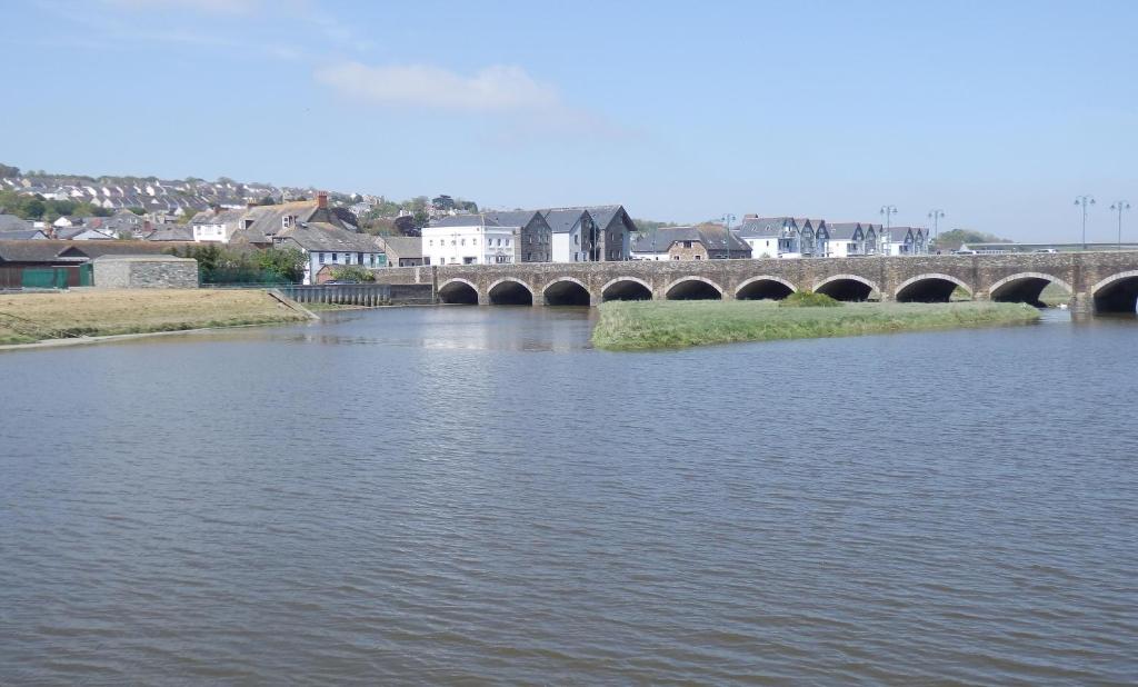 a bridge over a river with a town in the background at 7 Camelside in Wadebridge