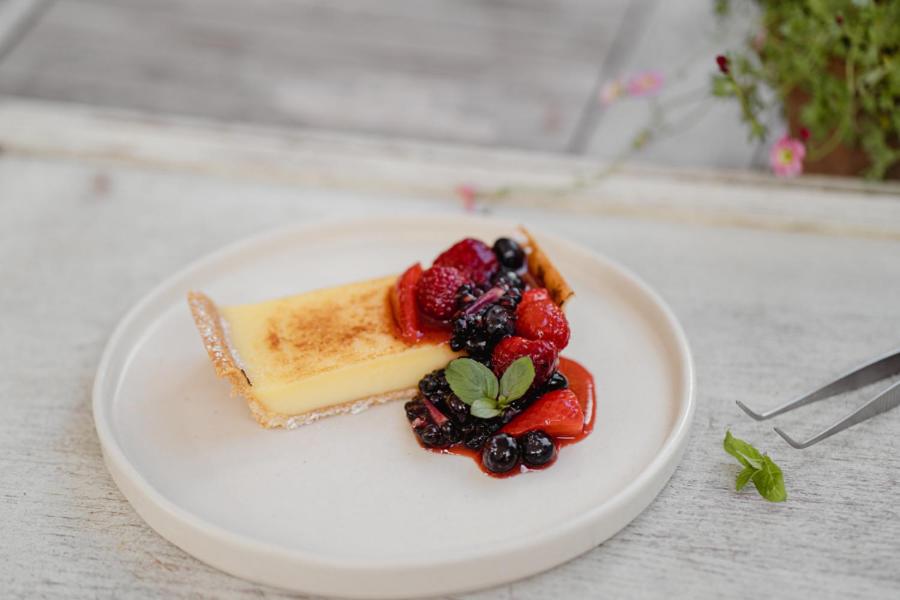 a piece of cake with berries on a white plate at The Bonnie Badger in Gullane