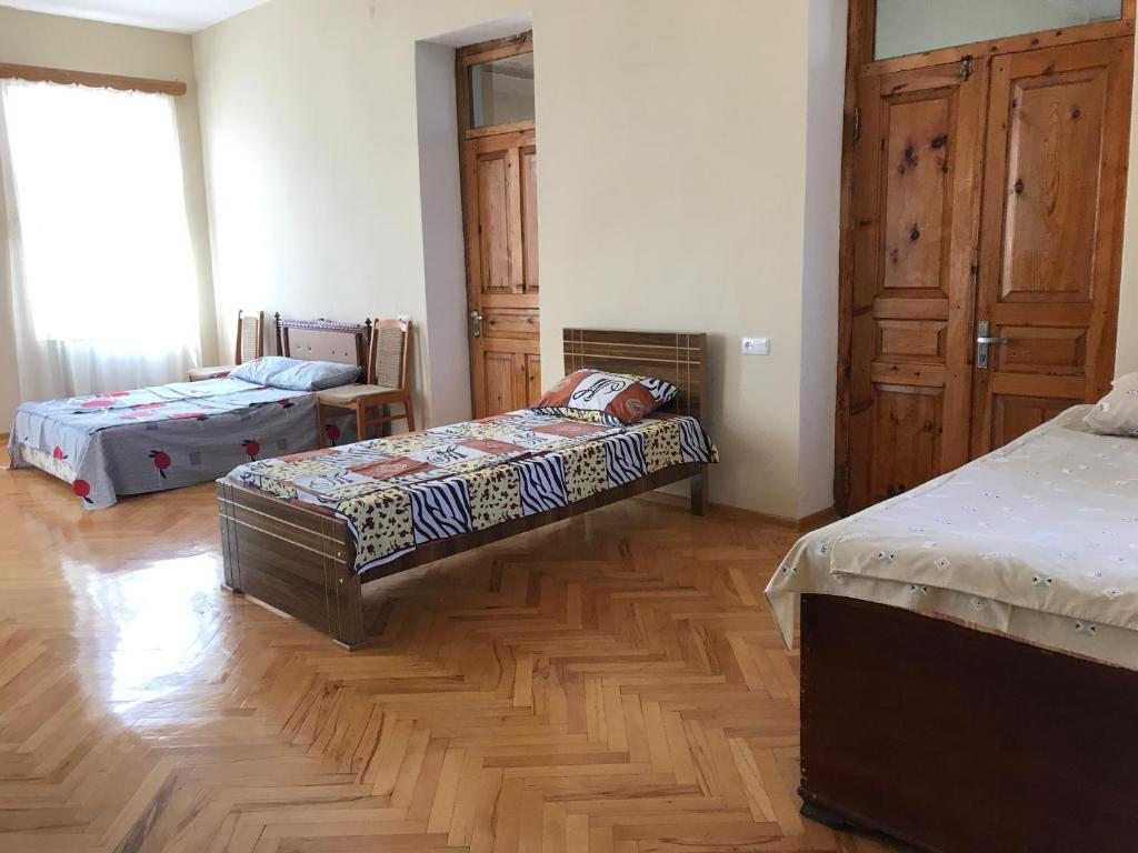 a bedroom with two beds and a wooden floor at Guesthouse "KISTAURI" in Telavi