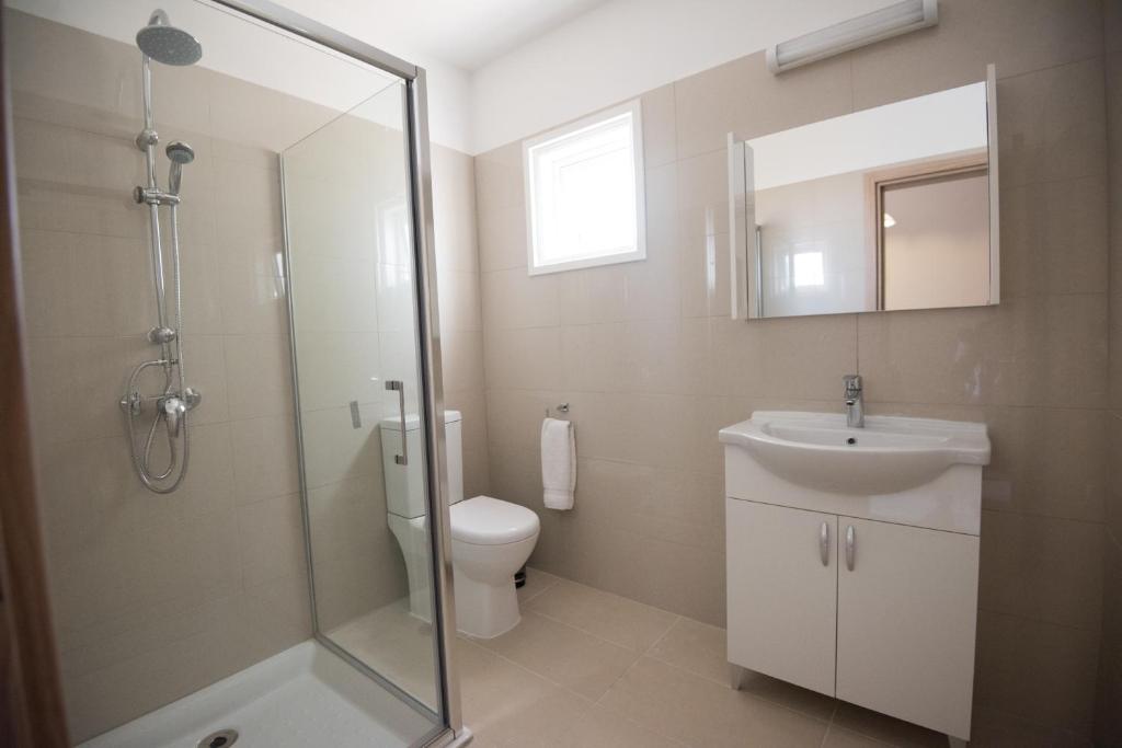 a bathroom with a shower and a toilet and a sink at Bellini Hotel in Ayia Napa