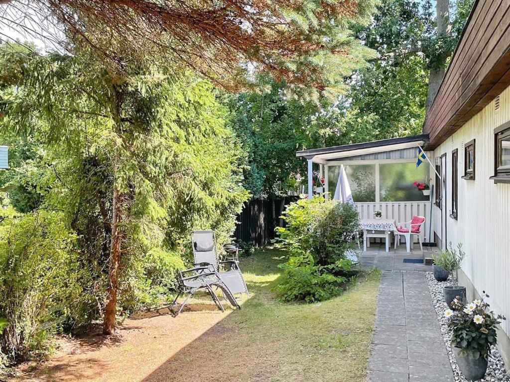 a backyard with a bench and a table and chairs at 3 person holiday home in HUNVIGAN-By Traum in Höllviken