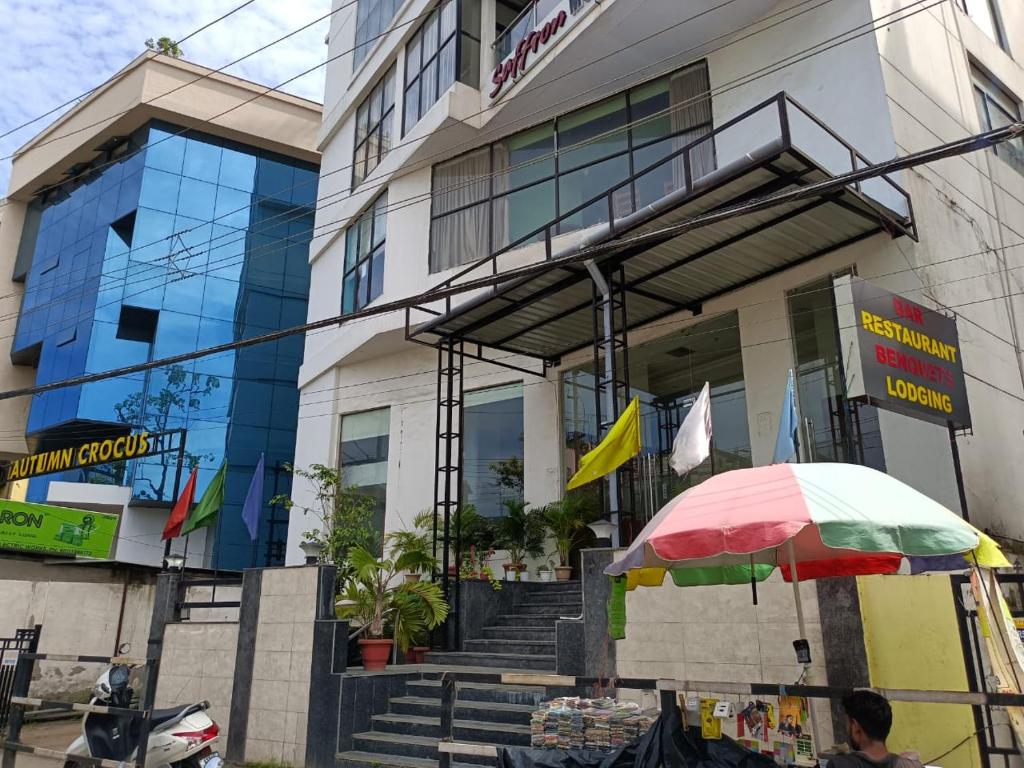 a man with an umbrella in front of a building at Hotel Autumn Crocus in Guwahati