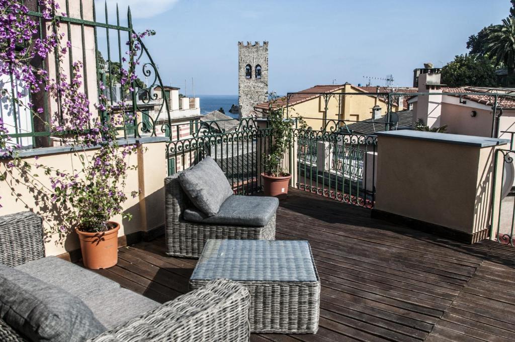 un patio con 2 sedie e un tavolo sul balcone di Zia Letizia Bed And Wine a Monterosso al Mare