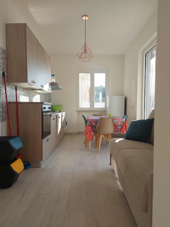 a living room with a couch and a kitchen at MARE.MORA Case vacanza Palinuro in Palinuro
