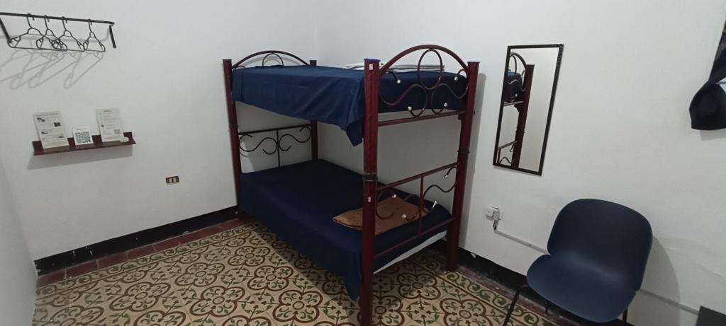 Pokój z 2 łóżkami piętrowymi i niebieskim krzesłem w obiekcie Hostal Casa Azul, Chantli w mieście Orizaba