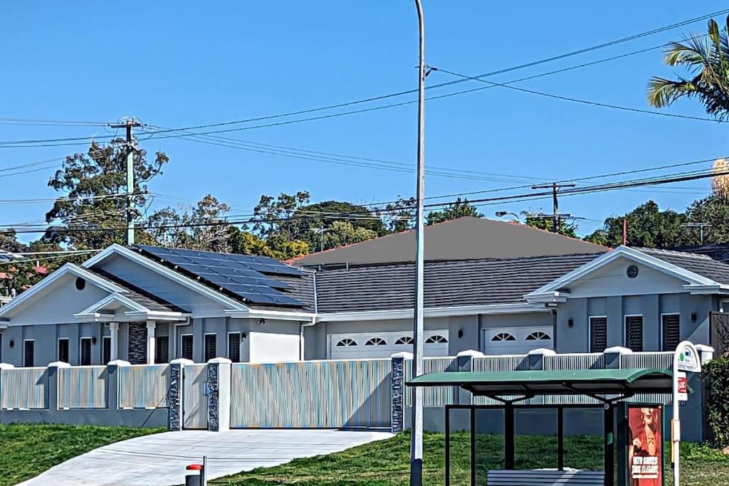 a white building with a fence in front of it at Entire House near Brisbane City 2Beds in Brisbane