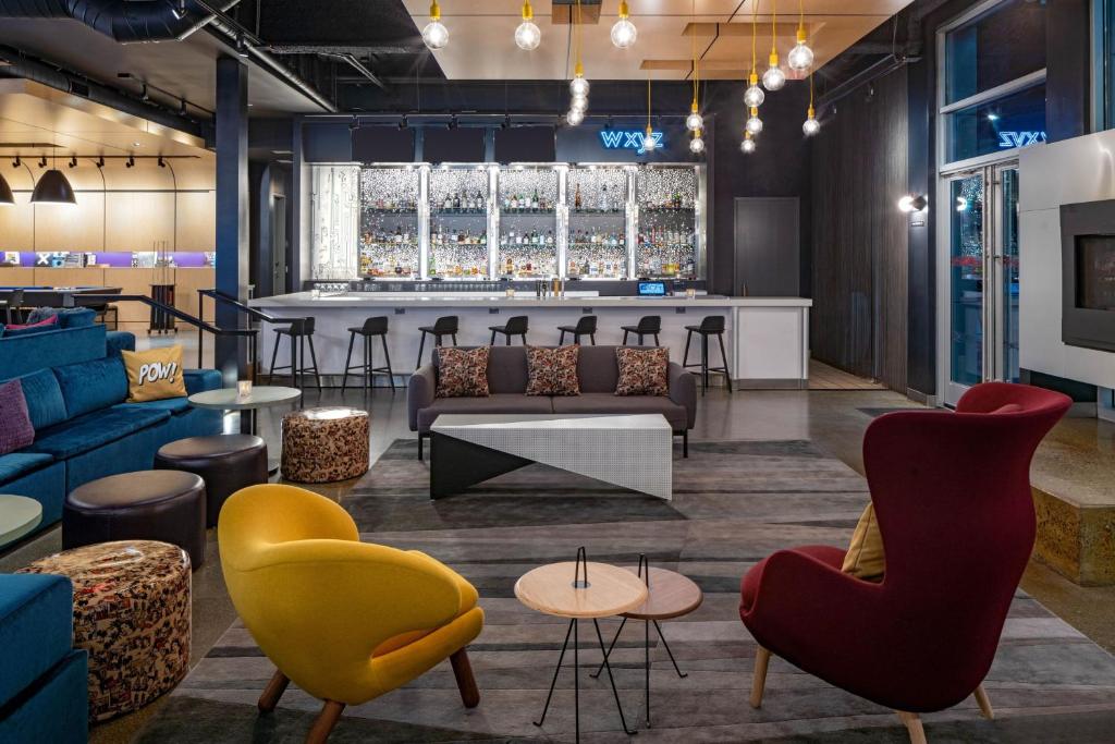 a lobby with couches and chairs and a bar at Aloft by Marriott Santa Clara in San Jose