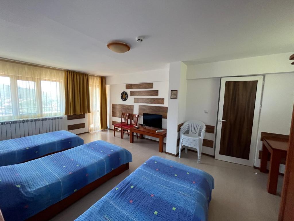Centaur Family Hotel في ريلا: غرفة فندقية بسريرين ومكتب