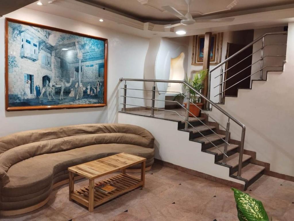 salon z kanapą i spiralnymi schodami w obiekcie Hotel Shripad Continental w mieście Amravati