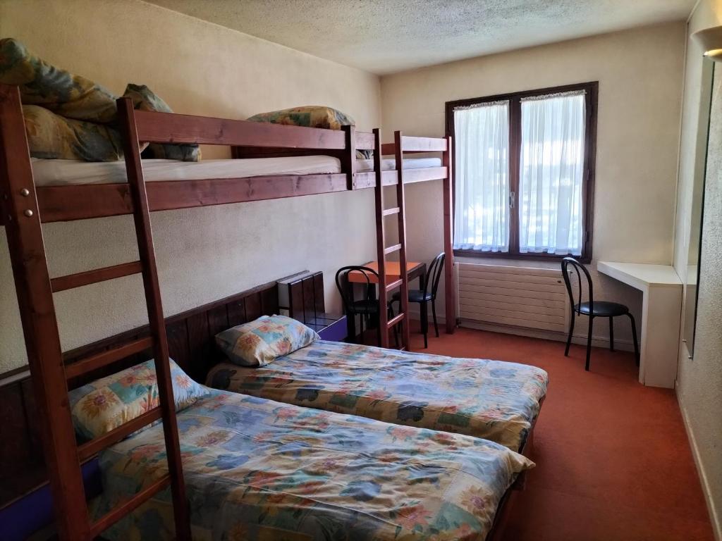 a room with two bunk beds and a table at Chambre Quadruple avec Salle de Bains Privative 1 in Vallouise
