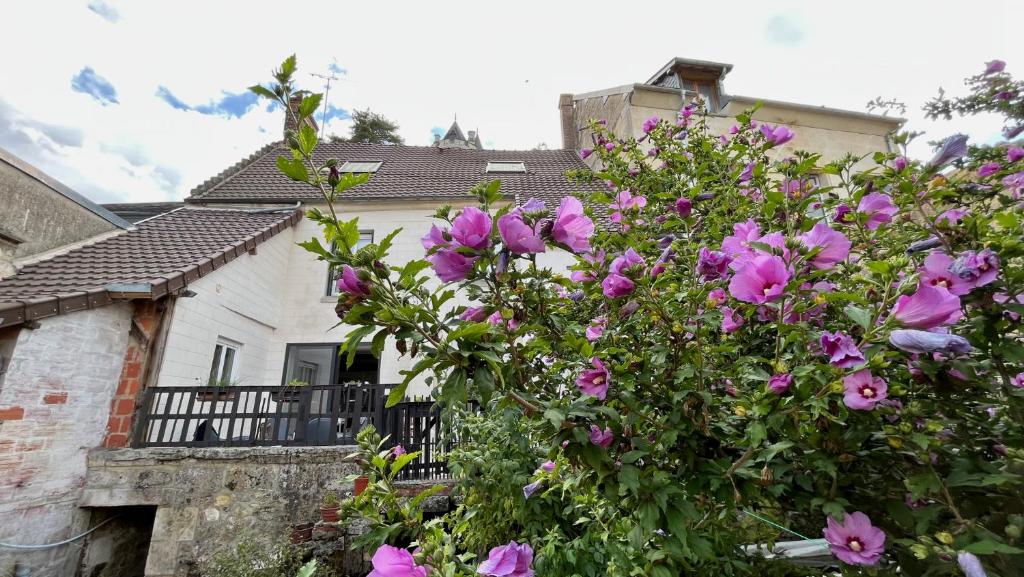 a bush of pink flowers in front of a house at L&#39;Escapade de Pierrefonds par Your Sweet Loc in Pierrefonds