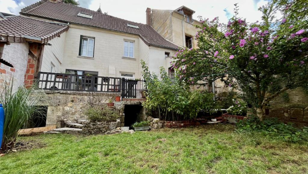 a house with a yard with a tree in front of it at L&#39;Escapade de Pierrefonds par Your Sweet Loc in Pierrefonds
