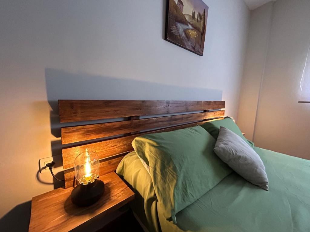 a bedroom with a bed with a wooden head board at Casa Rural Cerezo in Torviscón
