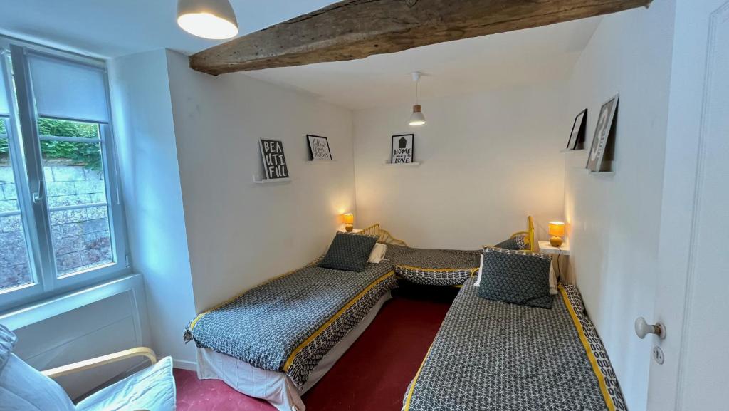 a room with two beds and a window at L&#39;Escapade de Pierrefonds par Your Sweet Loc in Pierrefonds