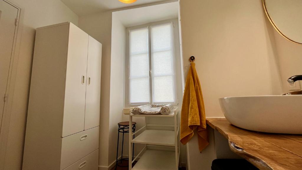 a bathroom with a white sink and a window at L&#39;Escapade de Pierrefonds par Your Sweet Loc in Pierrefonds