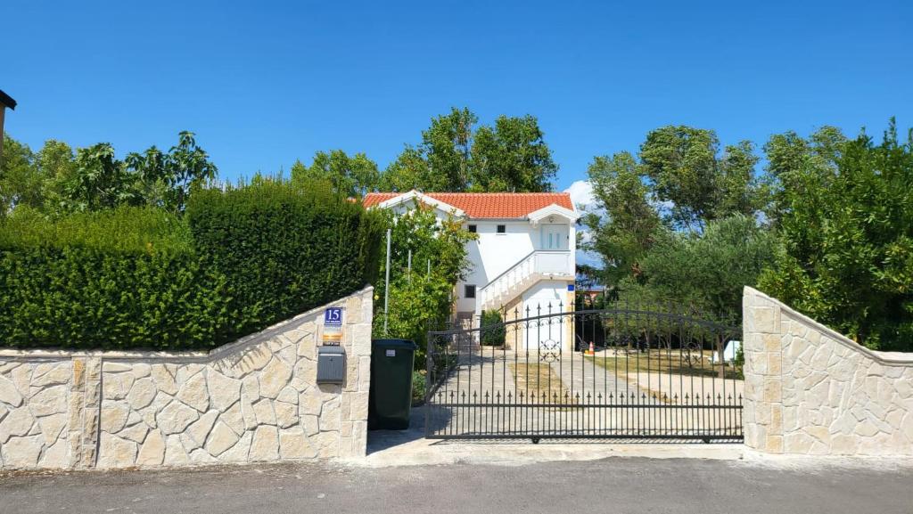 un portail en face d'une maison avec une clôture dans l'établissement villa.sunny.nin, à Nin