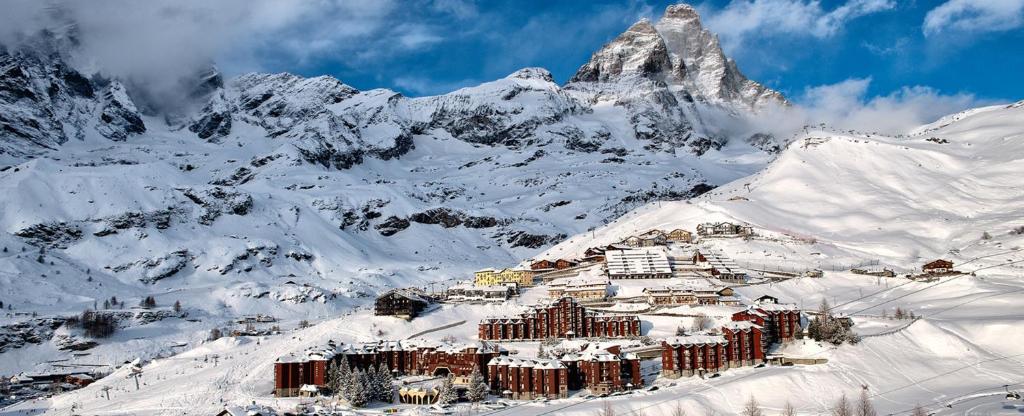 a resort in the snow in front of a mountain at Residence Cervinia Due - Maisonnette nr A7A04 in Breuil-Cervinia