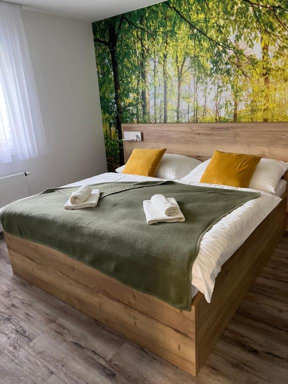 1 dormitorio con 1 cama grande de madera y toallas. en Apartmán - Dolní Morava - "Sedmička" pro 2 až 6 osob, en Dolní Morava