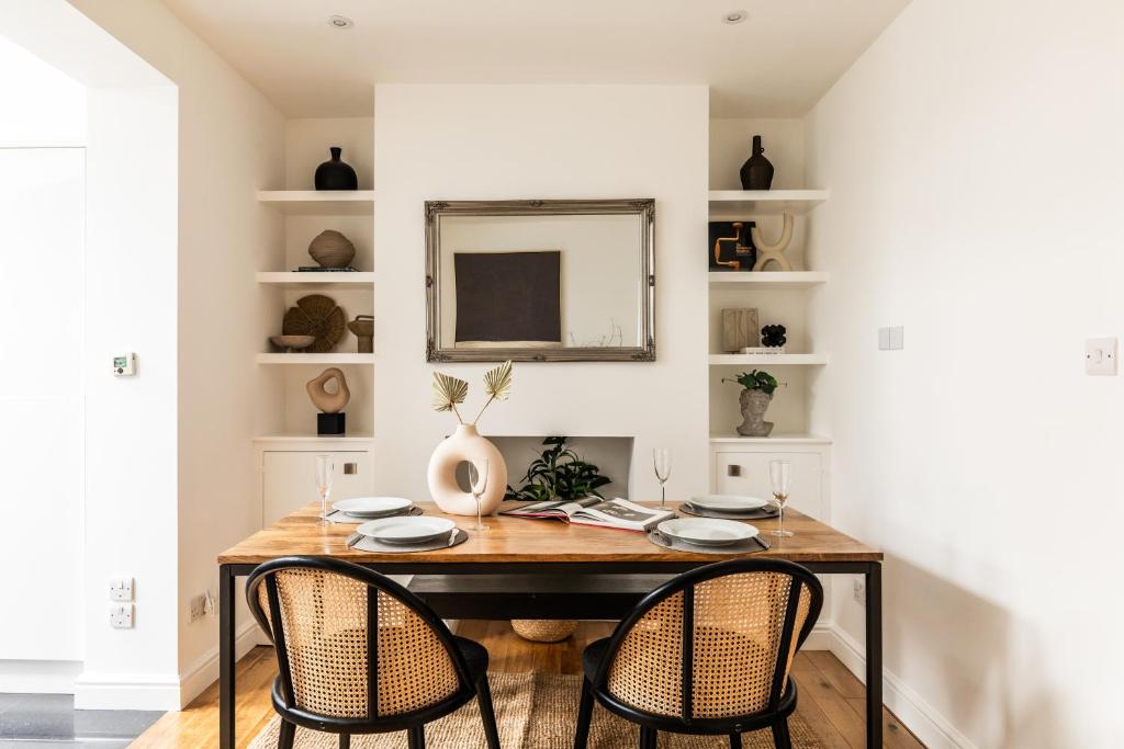 a dining room table with two chairs and a mirror at The Broadway Bath - 2 Bedrooms with parking, Central Bath in Bath