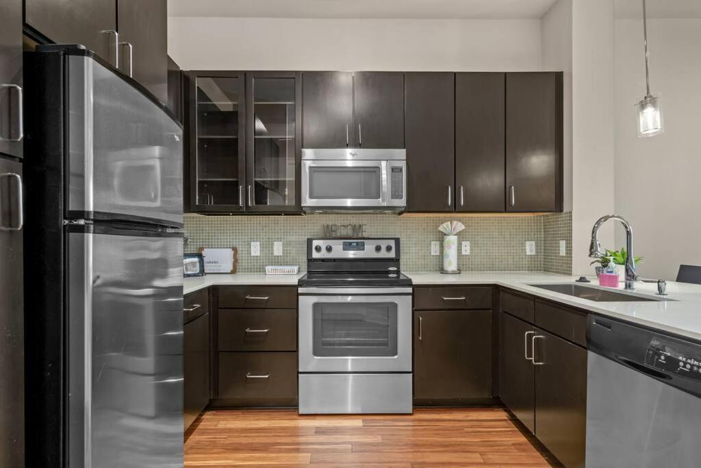 a kitchen with stainless steel appliances and wooden cabinets at 1BRModern Retreat-Mins to Med Center in Houston