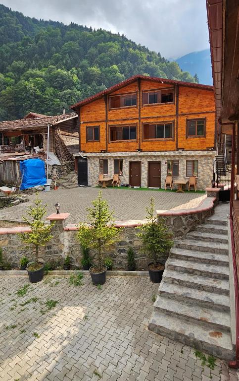 a large wooden building with trees in front of it at Uzungöl Sakin Pansiyon in Uzungöl