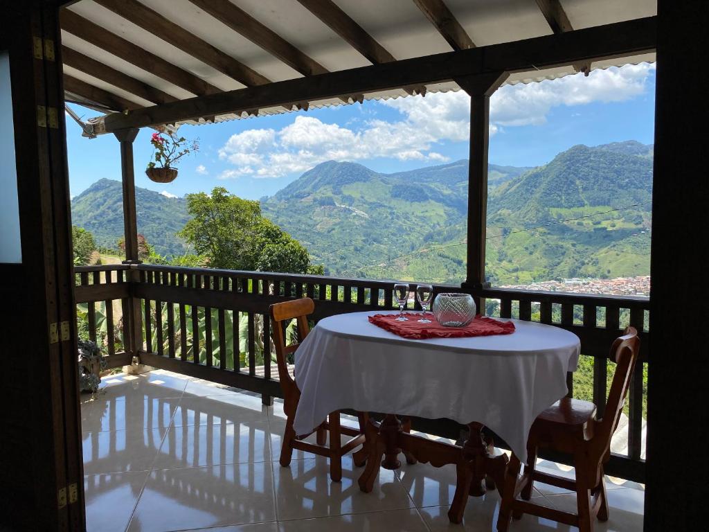 a table on a balcony with a view of mountains at Cabaña Noche De Luna in Jardin