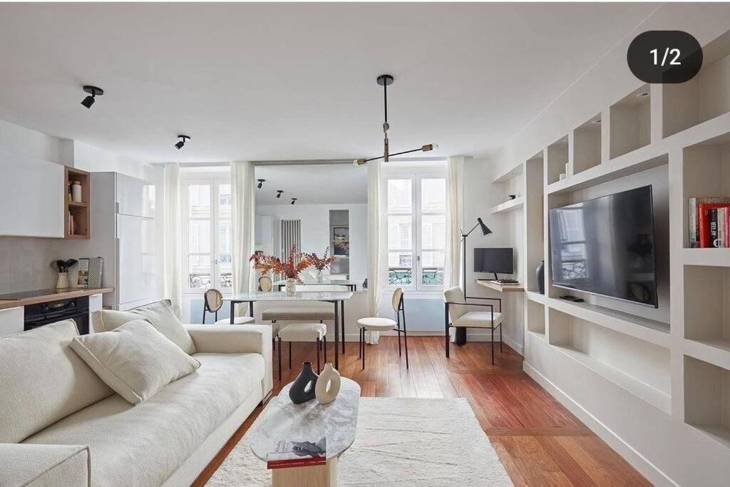 un salon avec un canapé blanc et une télévision dans l'établissement Apt design, proche Champs Elysées, à Paris