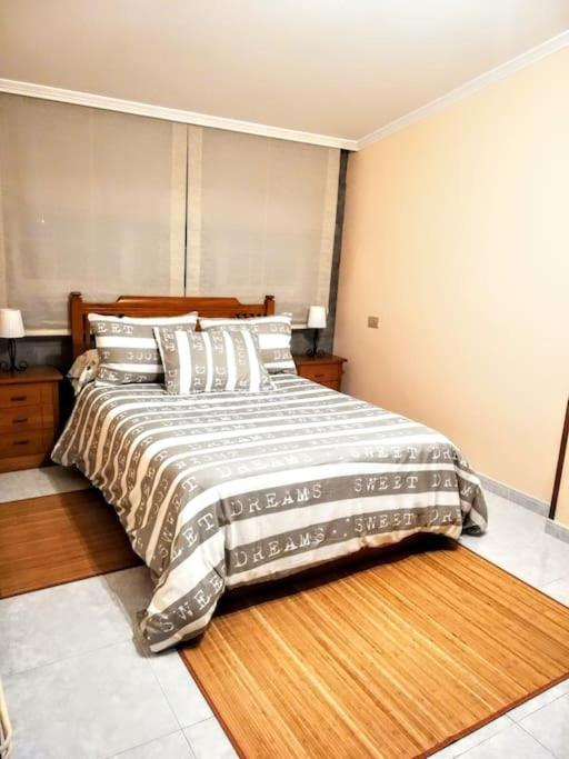 a bedroom with a large bed with a wooden headboard at Apartamento en las afueras in Ribadeo