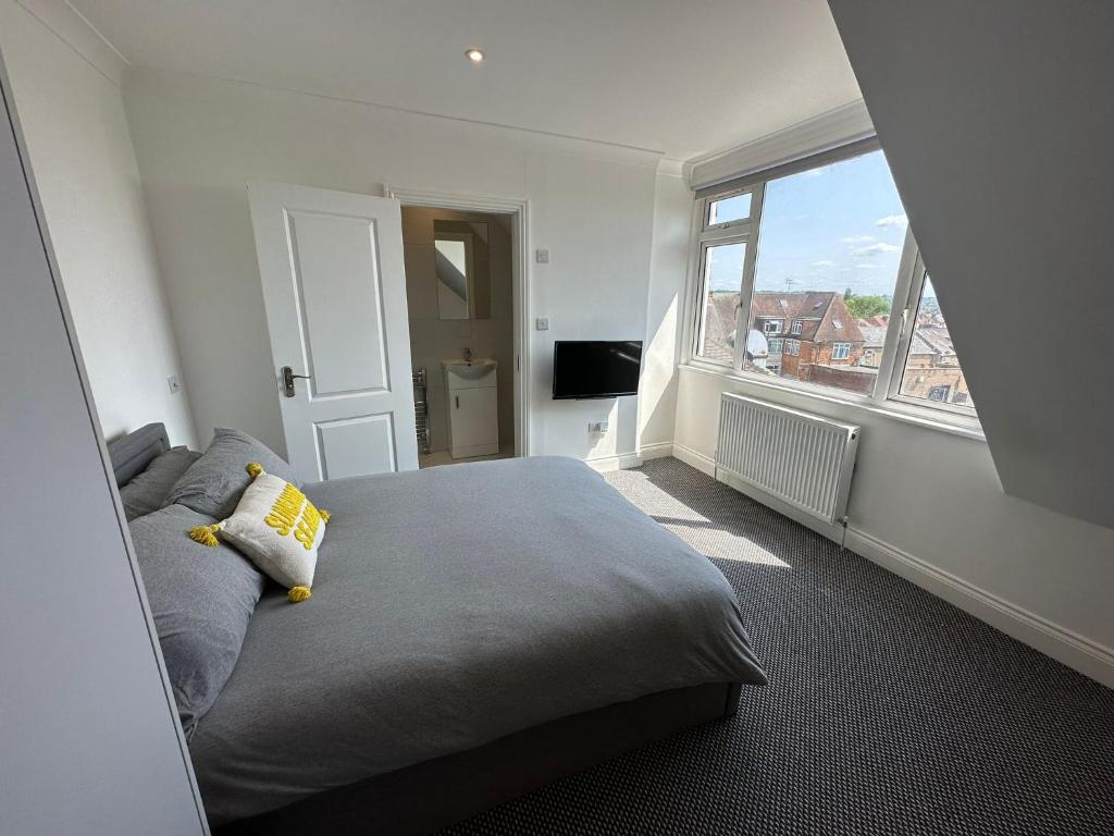 a bedroom with a bed and a large window at Stylish Modern, 1 Bed Flat, 15 Mins To Central London in Hendon