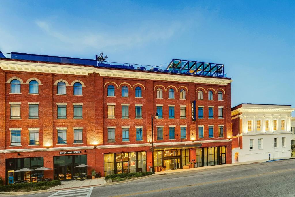 a large red brick building on a street at Trilogy Hotel Montgomery, Autograph Collection in Montgomery