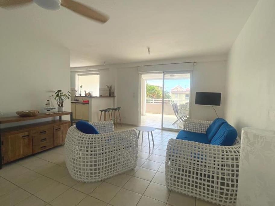 a living room with two chairs and a table at Les terrasses de la Marina in Le Marin