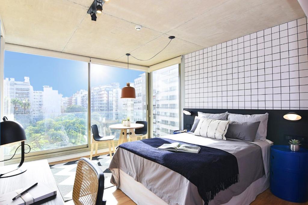 1 dormitorio con cama y ventana grande en Vistas Panorámicas al Parque en Montevideo