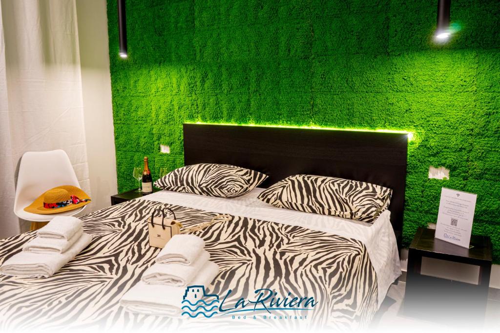 a bedroom with a zebra print bed with a green wall at La Riviera in Scalea