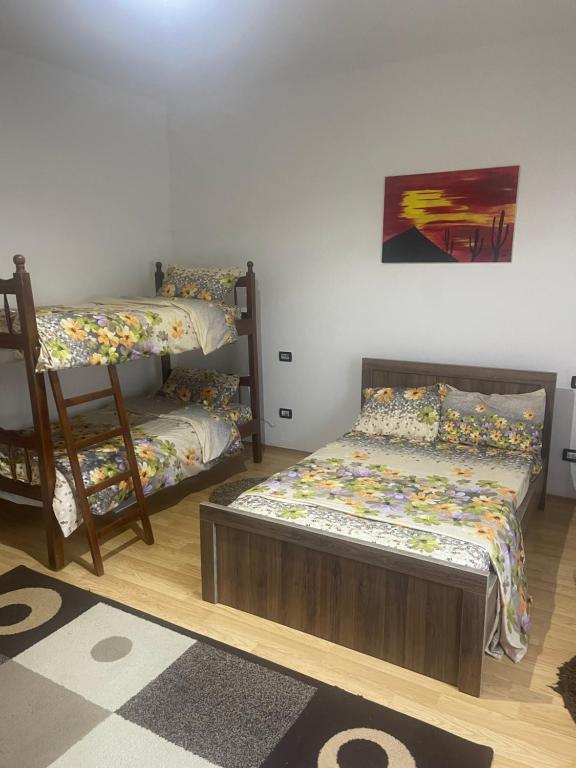 a bedroom with two bunk beds and a rug at Bujtina Rakaj in Bogë