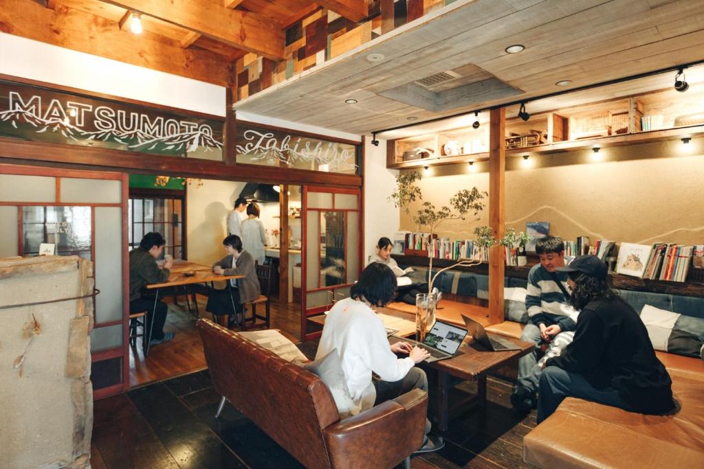 un grupo de personas sentadas en mesas en un restaurante en tabi-shiro, en Matsumoto