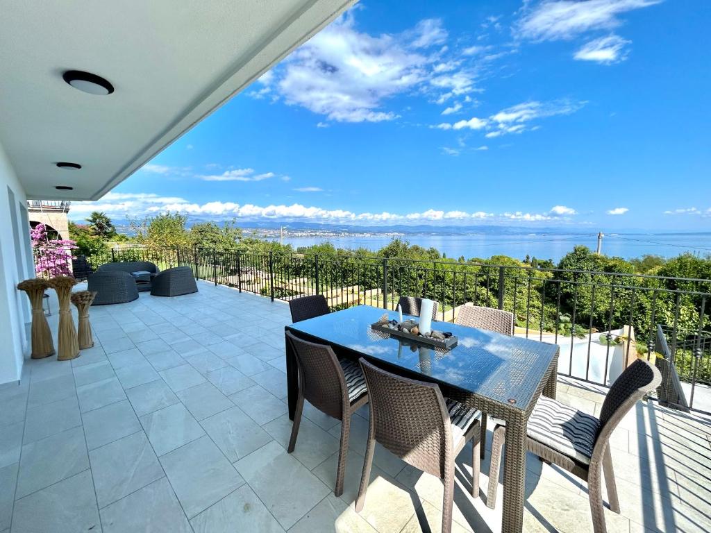 - une table et des chaises sur une terrasse avec vue sur l'eau dans l'établissement Villa Palma, à Lovran