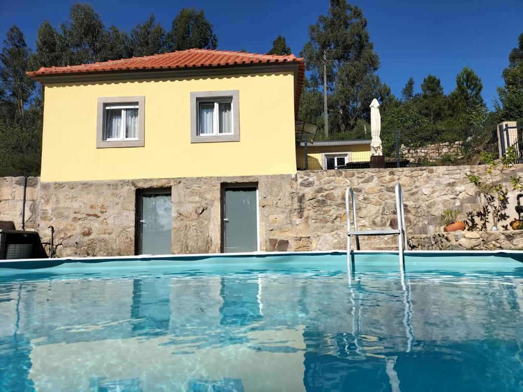une maison et une piscine en face d'une maison dans l'établissement Casa Davó Cinda, à Paredes de Coura