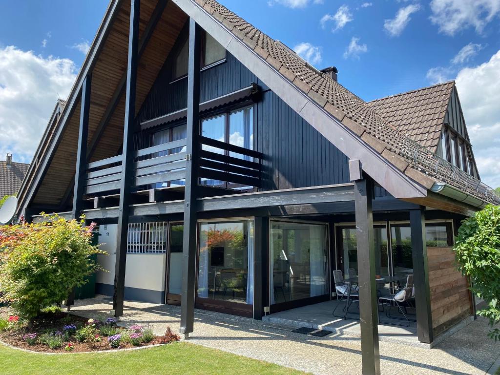 une maison avec des portes en verre et un toit dans l'établissement Ferienhaus Igel, à Owingen