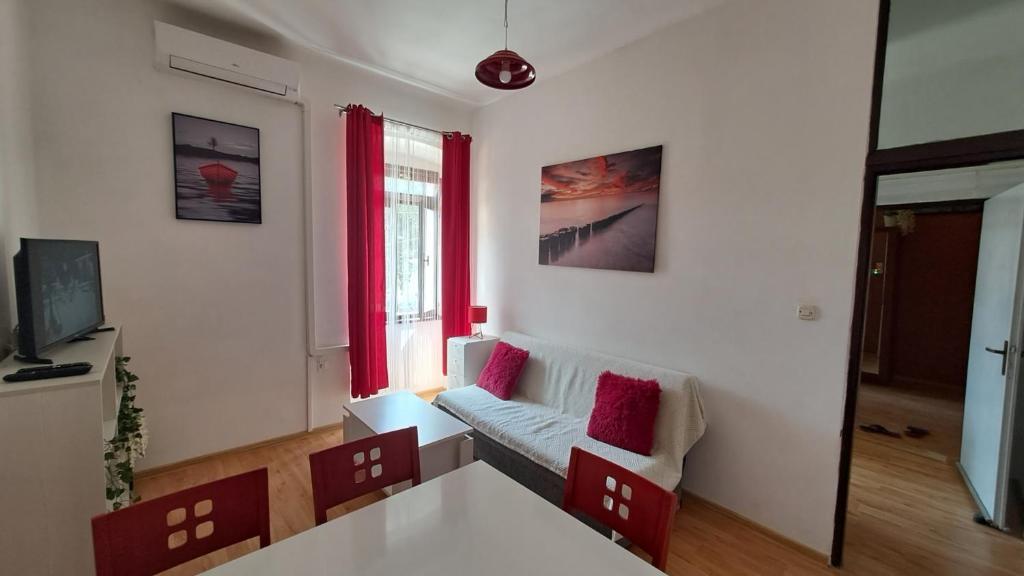 a living room with a couch and a table at Red blue with private parking and Gray blue apartment in Pula