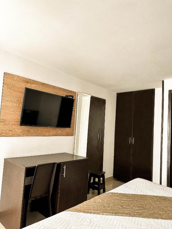 Una televisión o centro de entretenimiento en Sixth House Suite